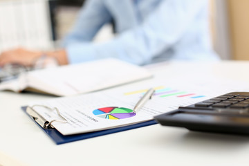 Financial statistics documents on clipboard pad at