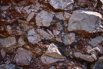 Rock with inclusion of light stones for backdrop. Color - Monsoon, Barossa, Hue Violet. Protruding relief, veins. Daylight.