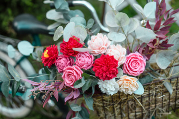 Beautiful bicycle with flowers in a basket stands on an avenue