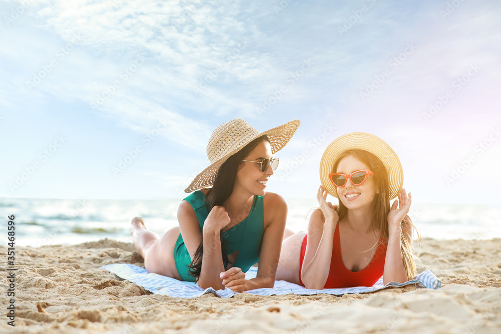 Canvas Prints Beautiful young women lying on sea beach at resort