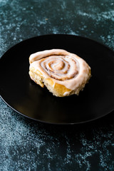 Cinnaom Roll / Cinnamon Bun with Cream in Dark Black Plate Ready to Eat