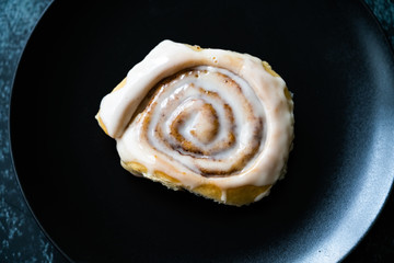 Cinnaom Roll / Cinnamon Bun with Cream in Dark Black Plate Ready to Eat