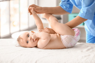 Massage therapist working with cute baby in medical center