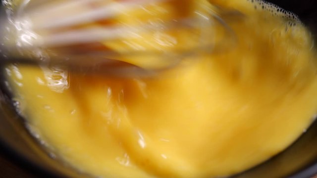 Preparing homemade omelette mixing with whisk eggs in 4K Resolution