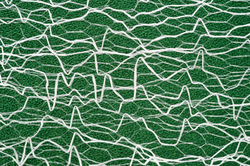 Obraz premium Guipure lying on a colored cloth, photographed close-up. Background for the texture of outerwear and fashion.