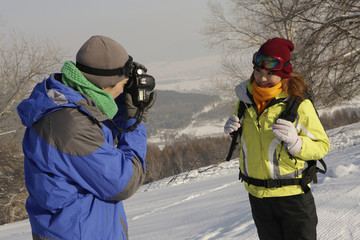 Man taking picture of woman on winter day