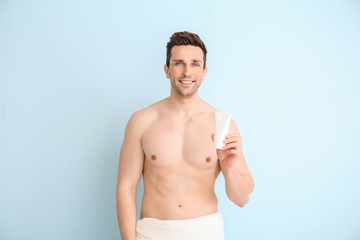 Fototapeta premium Handsome man with shower gel on color background