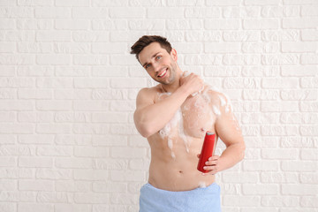 Obraz premium Handsome man taking shower against white background