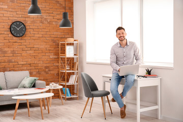 Man with laptop working at home