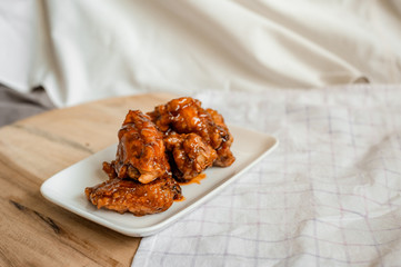 fried chicken wings with spicy sauce on cutting board