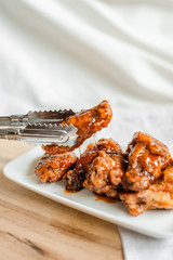 fried chicken wings with spicy sauce on cutting board