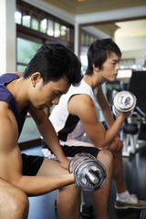 Fototapeta na wymiar Men lifting weights in gym