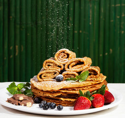pancakes with strawberries with mint leaves and a slice of butter on a plate, morning homemade...