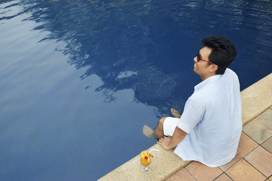 Man Relaxing By The Pool Side