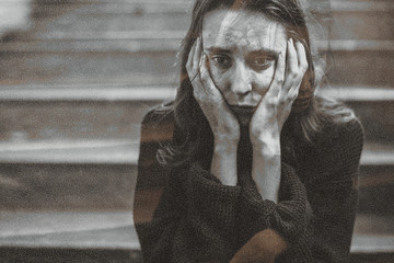 Distressed woman sitting on a staircase thinking deeply