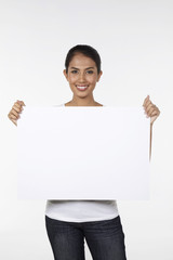 Woman smiling and holding a blank placard