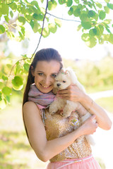 Young woman with her dog. Puppy white dog is running with it's owner. Concept about friendship, animal and freedom.