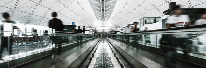 People on a moving walkway in a passenger terminal at the airport