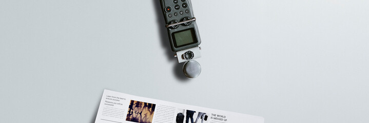 Portable sound recorder and a newspaper on a table