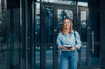 Busy woman is phoning when leaving office building.