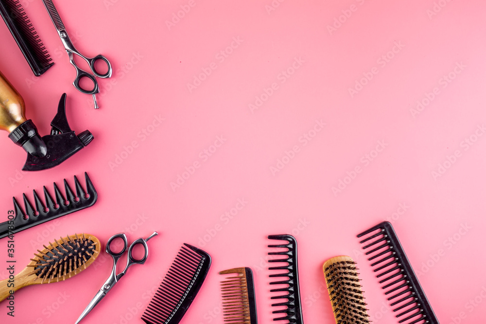 Wall mural Combs, hairbrush, scissors - hairdresser eqiupment - on pink table top-down space for text