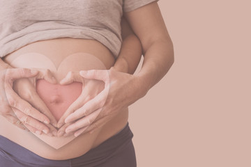 Pregnant woman on a beige background