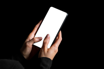 Person typing something on mobile phone with a blank white screen, photo isolated on black...