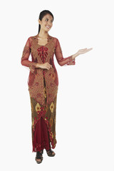 Woman in baju kebaya with welcoming hand gesture