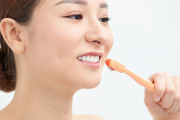 Studio portrait of a beautiful young woman holding a toothbrush with toothpaste on it