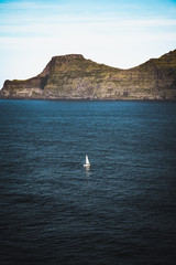 The Boat. Faroe Islands, Eysturoy. Lonely boat sailing through the sunny fjords of Eysturoy island.