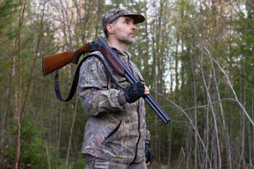 Fototapeta premium the hunter holds an unloaded rifle on his shoulder