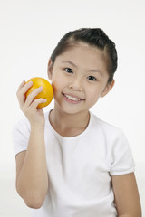 Girl smiling and holding an orange