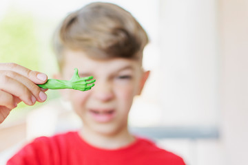 A little boy shows a craft made of plasticine