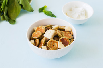 Spinach pancake cereals in a white bowl.