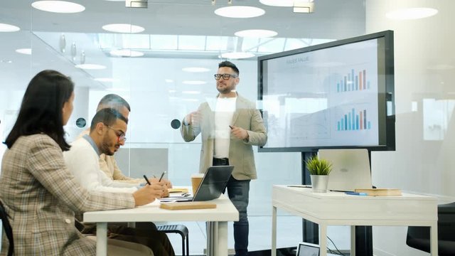 CEO talking to staff during briefing using digital interactive whiteboard in office planning marketing strategy. People, management and sales concept.