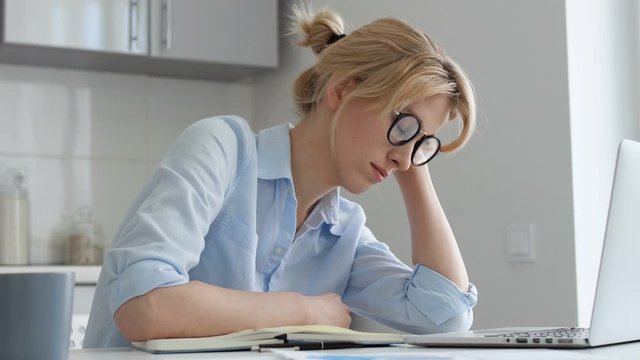 Exhausted woman falling asleep working on laptop bored work and studying at home