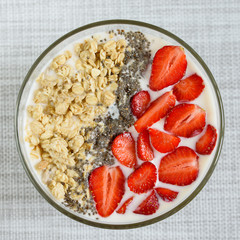 Healthy breakfast superfood smoothie bowl topped with granola and strawberry. close up. delicious berry smoothie bowl. vegan raw food. Selective focus. Flatlay