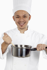 Asian chef cooking with saucepan