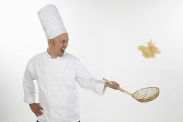 Naklejka premium Asian chef tossing noodles