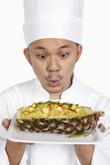 Asian chef with a plate of Thai pineapple fried rice