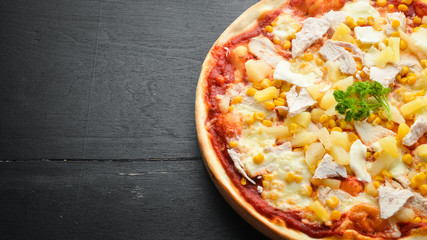 Traditional pizza with chicken, pineapple and corn. Top view. free space for your text. Rustic style.