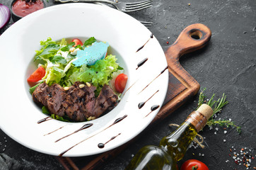 Vegetable salad with veal. Lettuce, veal, pine nuts, cherry tomatoes. Top view. Free space for your text.