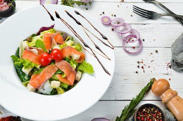 Vegetable salad with salted salmon and cherry tomatoes. Caesar salad with salmon. Top view. Free space for your text.