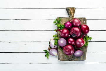 Purple fresh onion on white wooden background. Top view. Free copy space.