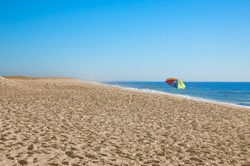 Fototapeta na wymiar Lonely beach with umbrella in the distance