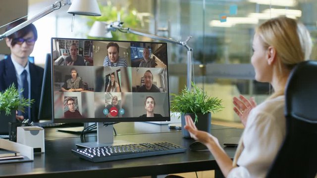 In the Office: Businesswoman Uses PC Conference Video Call Software App to Talk with a Group of Remote Working Colleagues. Businesspeople doing Online Meeting, Working from Office, Home Office