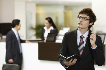 Businessman holding organizer, contemplating