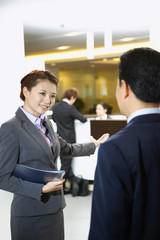 Sales representative of car dealership ushering customer to the counter
