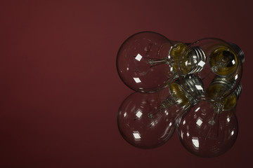 An old incandescent light bulb on red background
