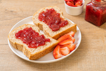 whole wheat bread with strawberry jam and fresh strawberry